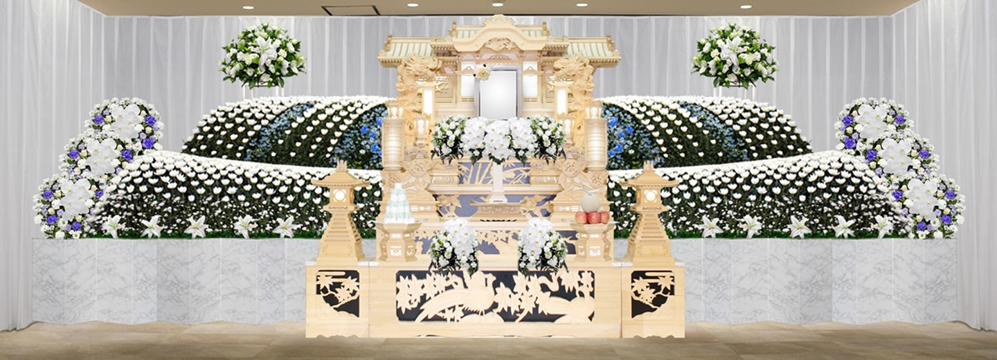 大型の白木祭壇と白・青の生花を組み合わせた祭壇例