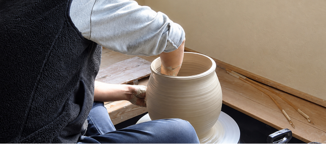 ろくろで骨壺を形作る職人の手仕事